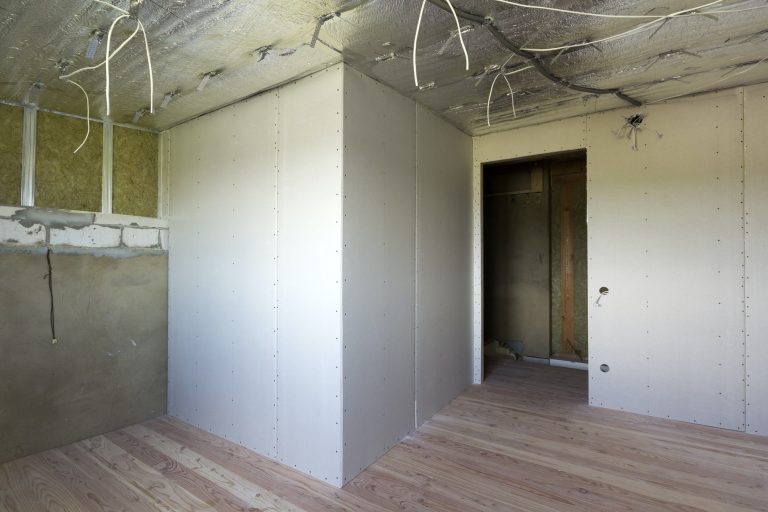 Room under construction with silver aluminum insulation foil and drywall on walls and ceiling